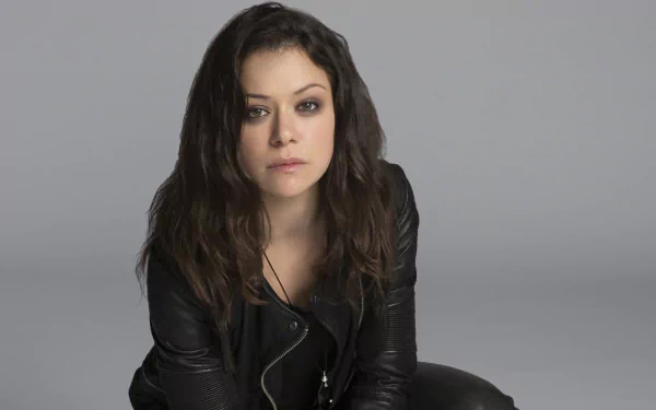 4K Ultra HD PC desktop wallpaper from the TV show Orphan Black: solitary woman in a black leather jacket against a neutral gray backdrop, intense, moody expression.