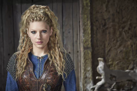 HD wallpaper featuring Katheryn Winnick as Lagertha from the TV show Vikings (2013), showcasing her striking gaze and detailed Viking attire against a rustic background.