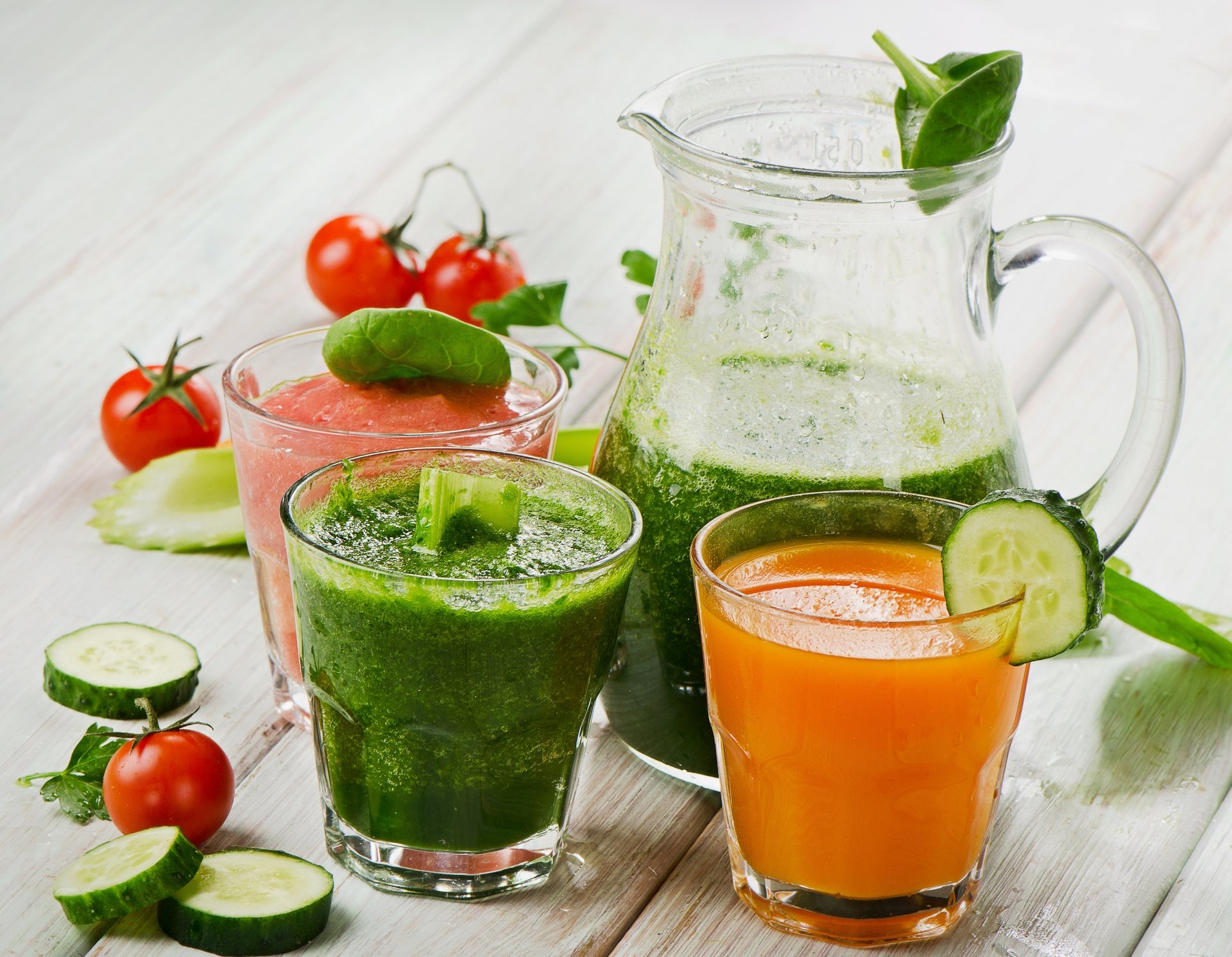 4K Ultra HD wallpaper featuring fresh cucumber, tomato, and green vegetable juices served in glasses and a pitcher, showcasing vibrant, healthy smoothie options.