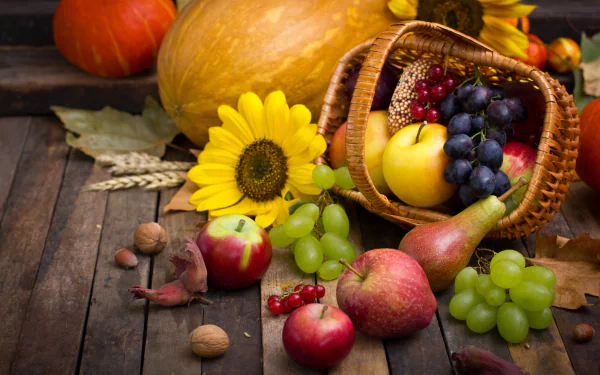 A vibrant 4K Ultra HD still life featuring a fall harvest of sunflowers, grapes, pears, apples, and pumpkins arranged on a rustic wooden surface.