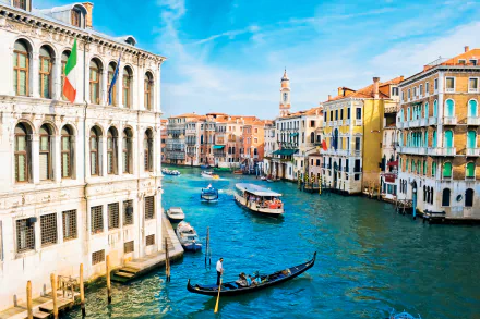 4K Ultra HD view of Venice's iconic canal with gondolas and colorful historic buildings under a bright blue sky, showcasing the charm of this man-made Italian cityscape.