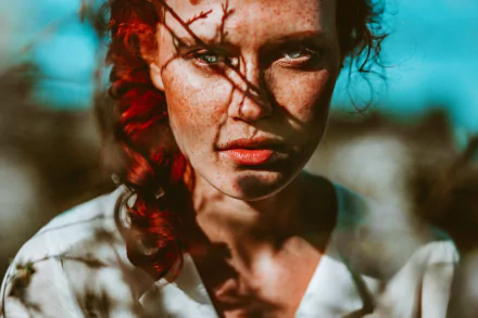 Close-up of a redhead woman with green eyes, freckles, and a braid, captured in vivid 4K Ultra HD detail against a blurred outdoor background.