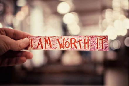 HD PC desktop wallpaper featuring a hand holding a handwritten I AM WORTH IT sign, conveying a clear motivational message.