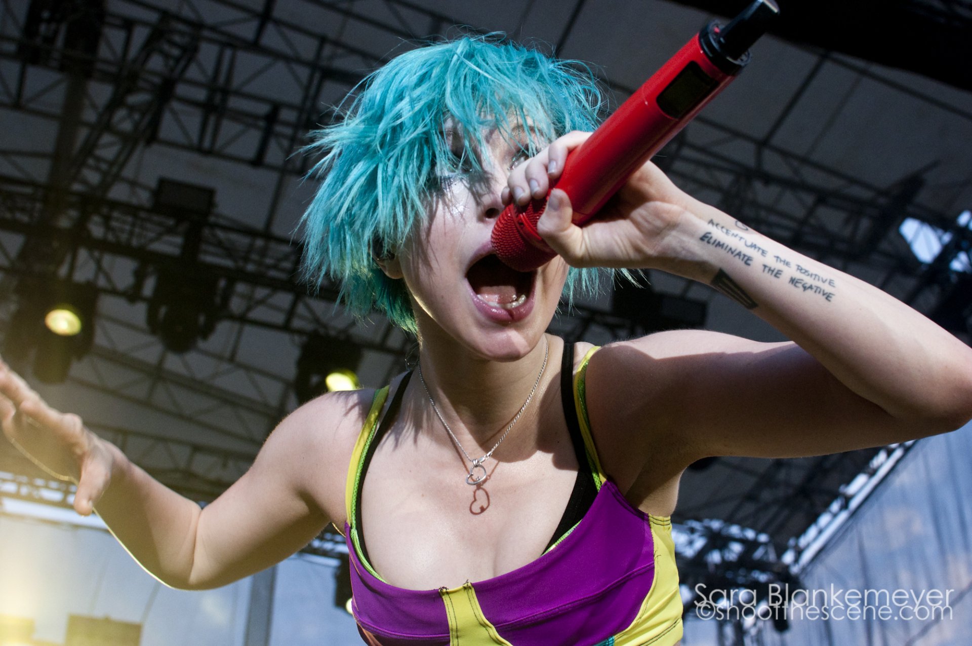 HD PC desktop wallpaper showing Hayley Williams passionately singing into a red microphone during a live music performance.