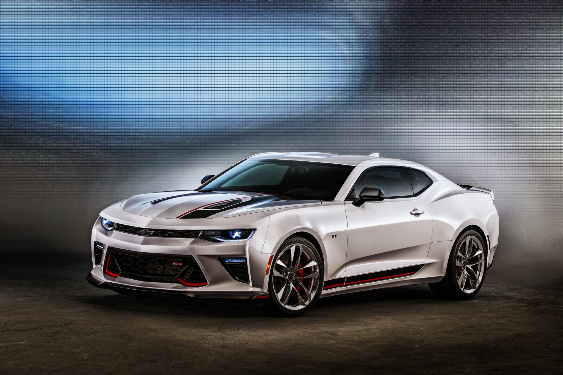A striking silver Chevrolet Camaro muscle car, showcased in an HD wallpaper format, with sleek lines and an aggressive stance against a blurred background.