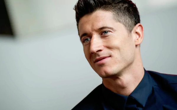 HD wallpaper featuring Polish soccer player Robert Lewandowski with a confident smile, dressed in a stylish outfit. The background is simple and blurred to highlight the athlete.