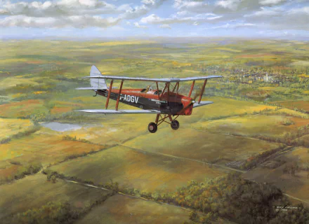 HD PC desktop wallpaper: military de Havilland Tiger Moth biplane flying over a patchwork countryside with blue sky and a distant village.