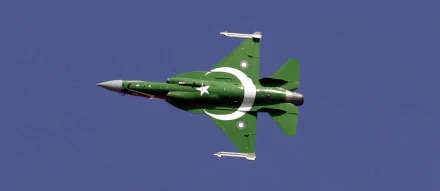 An HD PC desktop wallpaper featuring a CAC/PAC JF-17 Thunder fighter jet soaring through a clear blue sky, adorned in a striking green livery with a white crescent and star.