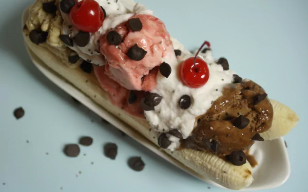 A vibrant 4K Ultra HD desktop wallpaper showcasing a delicious banana split with scoops of ice cream, whipped cream, chocolate chips, and cherries on top.
