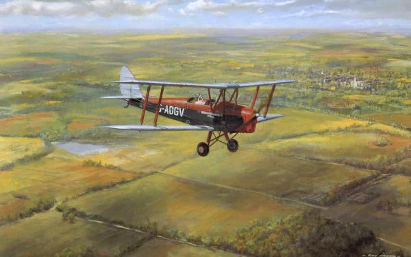 HD PC desktop wallpaper: military de Havilland Tiger Moth biplane flying over a patchwork countryside with blue sky and a distant village.