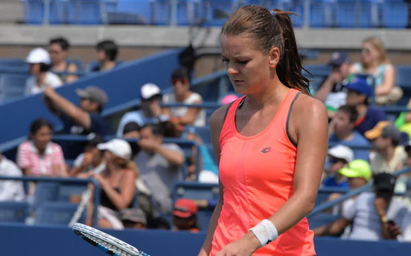5K Ultra HD PC desktop wallpaper of a Polish tennis player in a neon orange top on court, focused between points with a stadium crowd — sports action background.