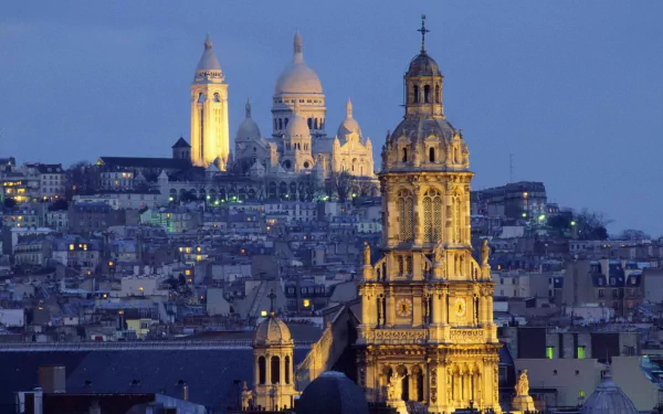 Illuminated Basilica of the Sacred Heart (Sacré‑Cœur) on Montmartre overlooking Paris at dusk — HD desktop wallpaper of France's man-made architectural skyline.