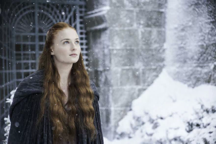 Sansa Stark, portrayed by Sophie Turner, stands amidst falling snow, evoking the dramatic atmosphere of Game of Thrones in this striking HD desktop wallpaper.