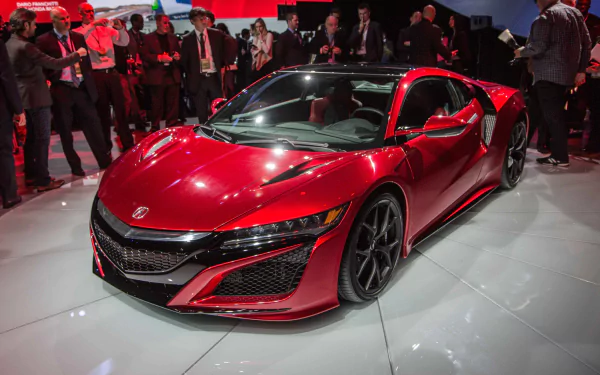 Red Acura NSX on display at an auto show, amidst a crowd, as an HD desktop wallpaper background.
