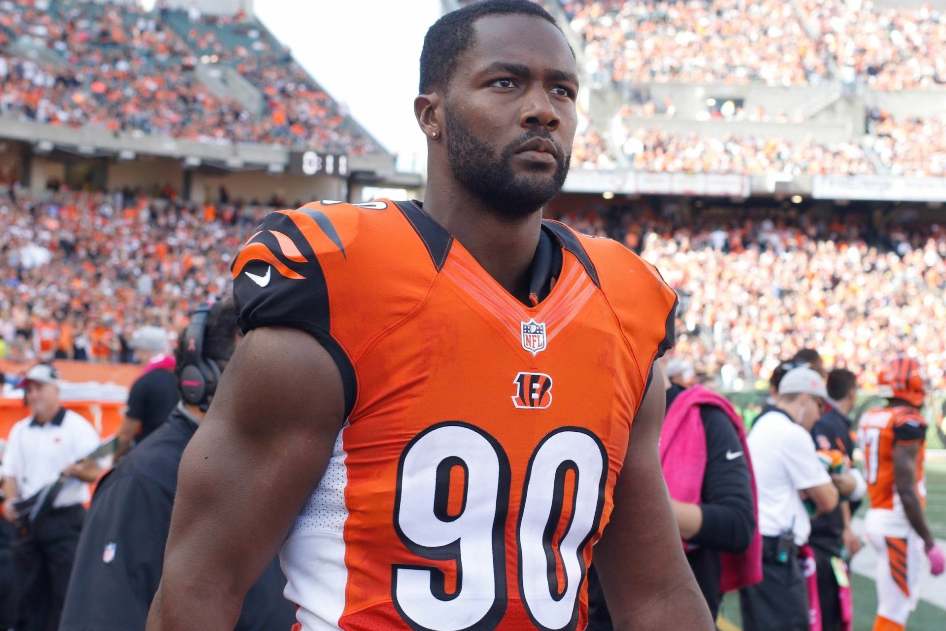 HD PC desktop wallpaper of a Cincinnati Bengals football player in orange No. 90 uniform standing on the sideline with a packed stadium crowd behind him.