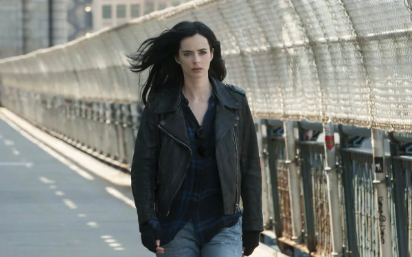 HD PC desktop wallpaper featuring Krysten Ritter as Jessica Jones from the TV show, walking with determination along a bridge walkway.