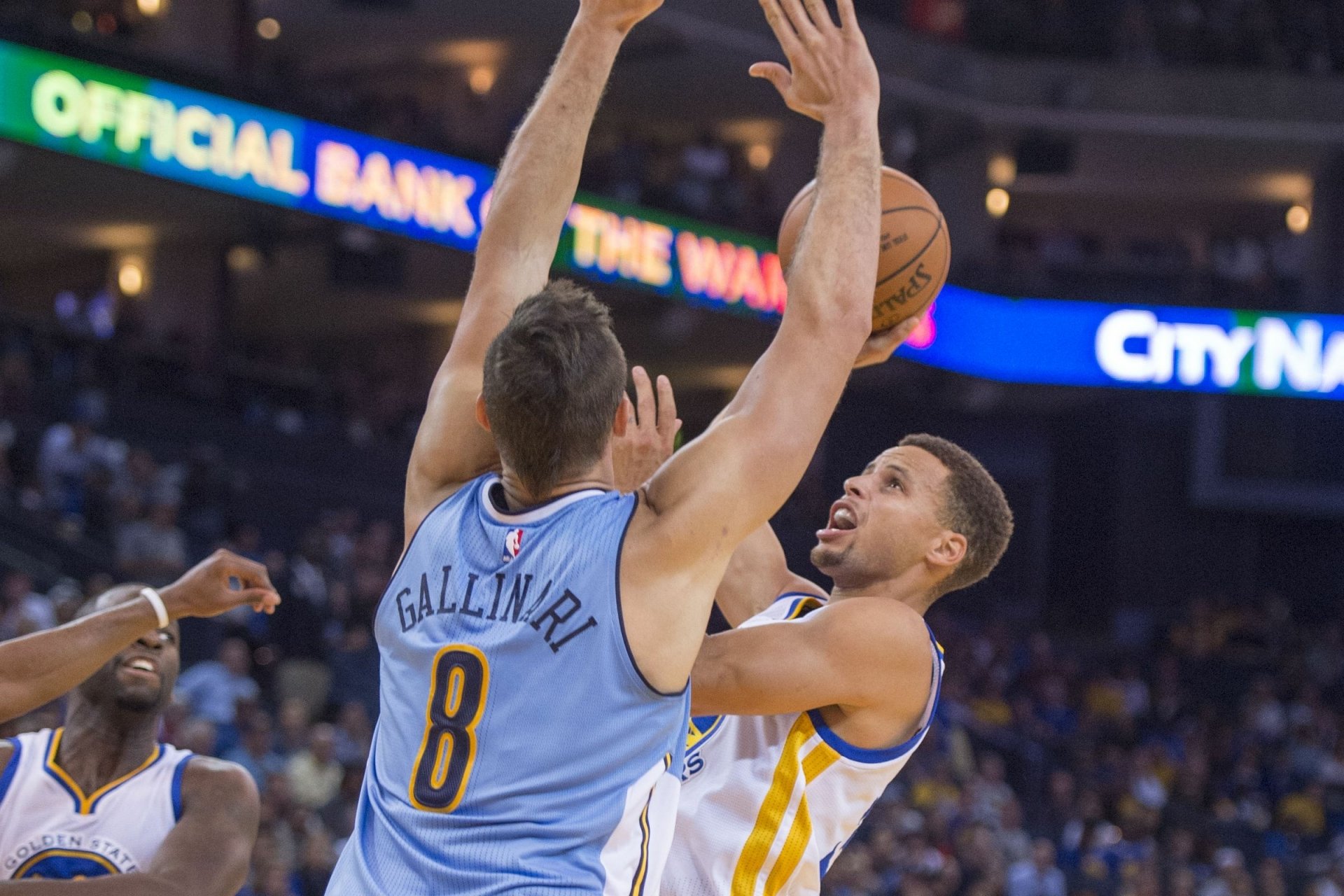A dynamic HD wallpaper featuring the Golden State Warriors in action, showcasing a player making a strong move against an opponent during a thrilling basketball game.