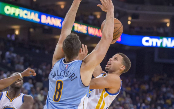 A dynamic HD wallpaper featuring the Golden State Warriors in action, showcasing a player making a strong move against an opponent during a thrilling basketball game.