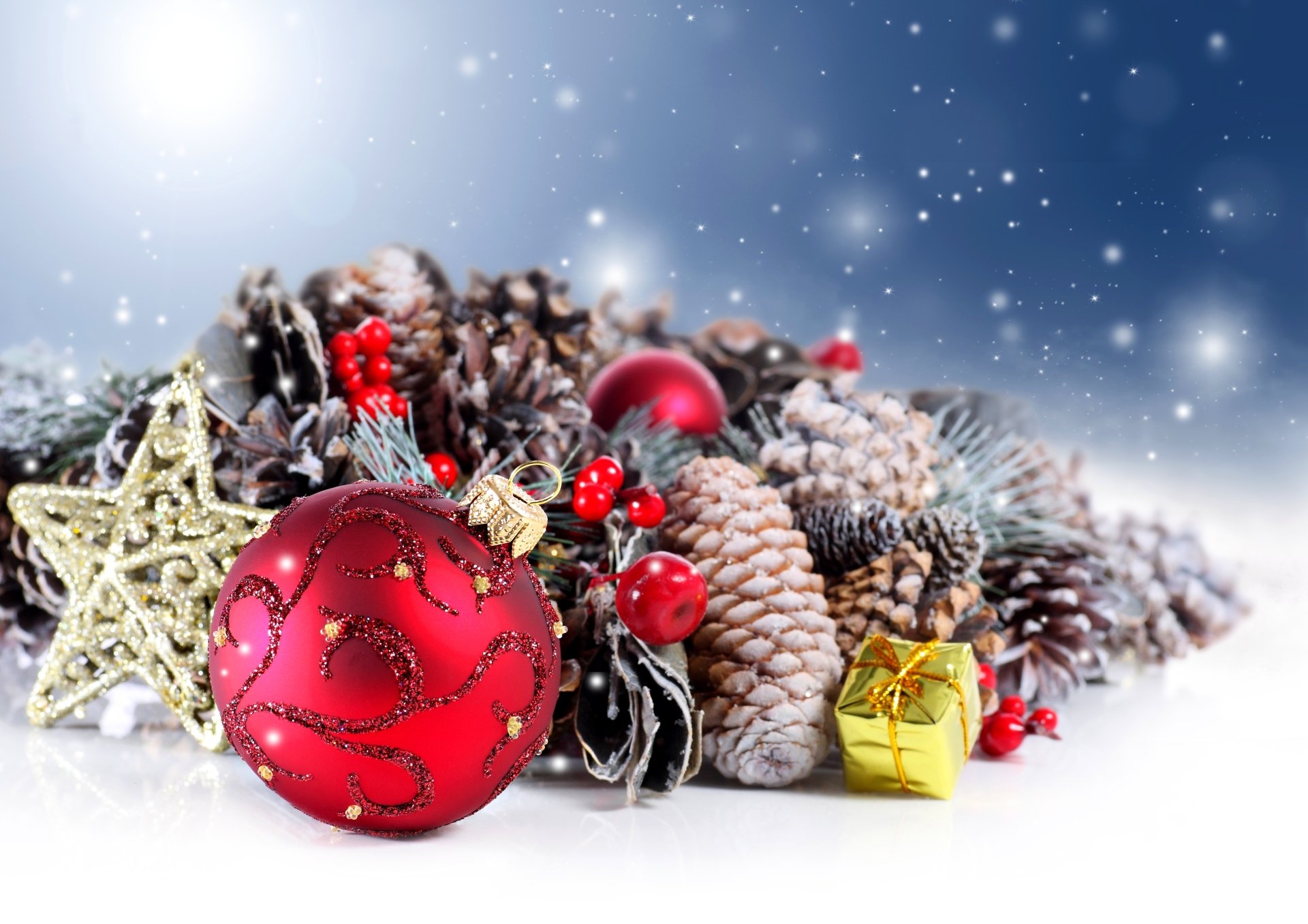 Festive holiday scene featuring pine cones, red Christmas ornaments, a golden star, and a small wrapped gift against a snowy, shimmering background in 4K Ultra HD.