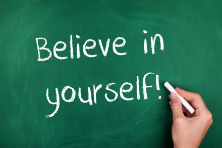 HD PC desktop wallpaper featuring a motivational message Believe in yourself! written in white chalk on a green chalkboard background.
