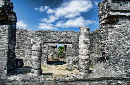 4K Ultra HD PC desktop wallpaper of man-made stone ruins at Tulum, Mexico — weathered columns and doorways framing blue sky and coastal vegetation.