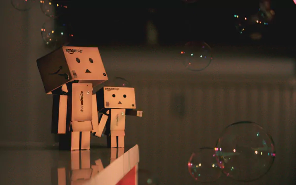 A 4K Ultra HD PC desktop wallpaper featuring two Danbo figures holding hands amid softly glowing bubbles in a dimly lit, cozy setting.