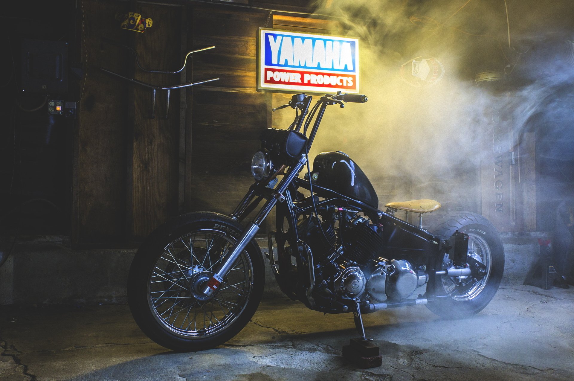 A Yamaha V Star bike displayed in a dimly lit garage with a glowing Yamaha Power Products sign, captured in HD for a striking PC desktop wallpaper.