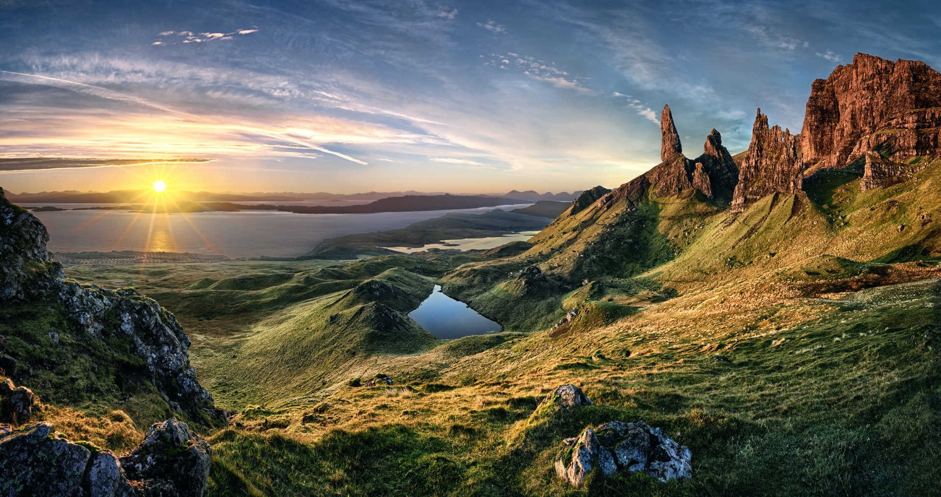 A stunning HD landscape featuring a tranquil lake surrounded by cliffs, lush greenery, and a breathtaking sunrise that illuminates the natural beauty of the scene.