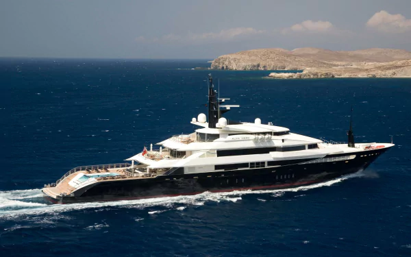 HD PC desktop wallpaper: a luxury yacht (vehicle) cruising deep blue sea past a rocky coastline under a clear sky.