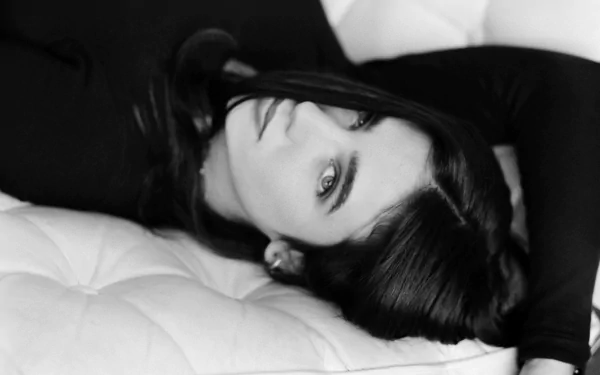 Black and white HD desktop wallpaper featuring celebrity Jennifer Connelly lying down with a serene expression against a textured background.