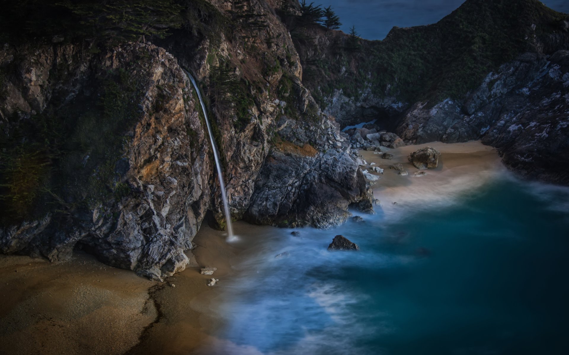 McWay Falls plunges onto a sandy Big Sur beach along a rugged coastline, turquoise ocean waters and rocky cliffs captured in a 4K Ultra HD PC desktop wallpaper background.