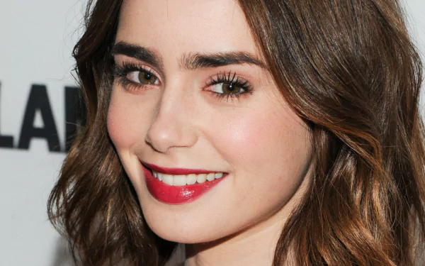 Close-up HD desktop wallpaper featuring celebrity Lily Collins smiling with natural makeup and red lipstick.