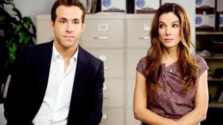 HD desktop wallpaper featuring Ryan Reynolds and Sandra Bullock as Margaret Tate in the movie The Proposal, set in an office environment.