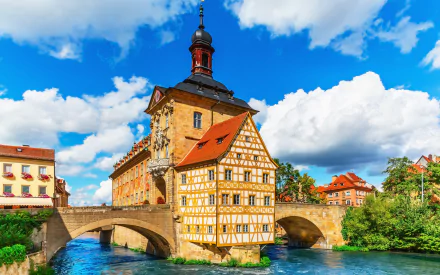HD desktop wallpaper showcasing Bamberg, Germany’s historic museum with traditional architecture beside a river under a vibrant blue sky.