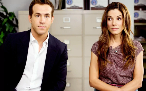 HD desktop wallpaper featuring Ryan Reynolds and Sandra Bullock as Margaret Tate in the movie The Proposal, set in an office environment.