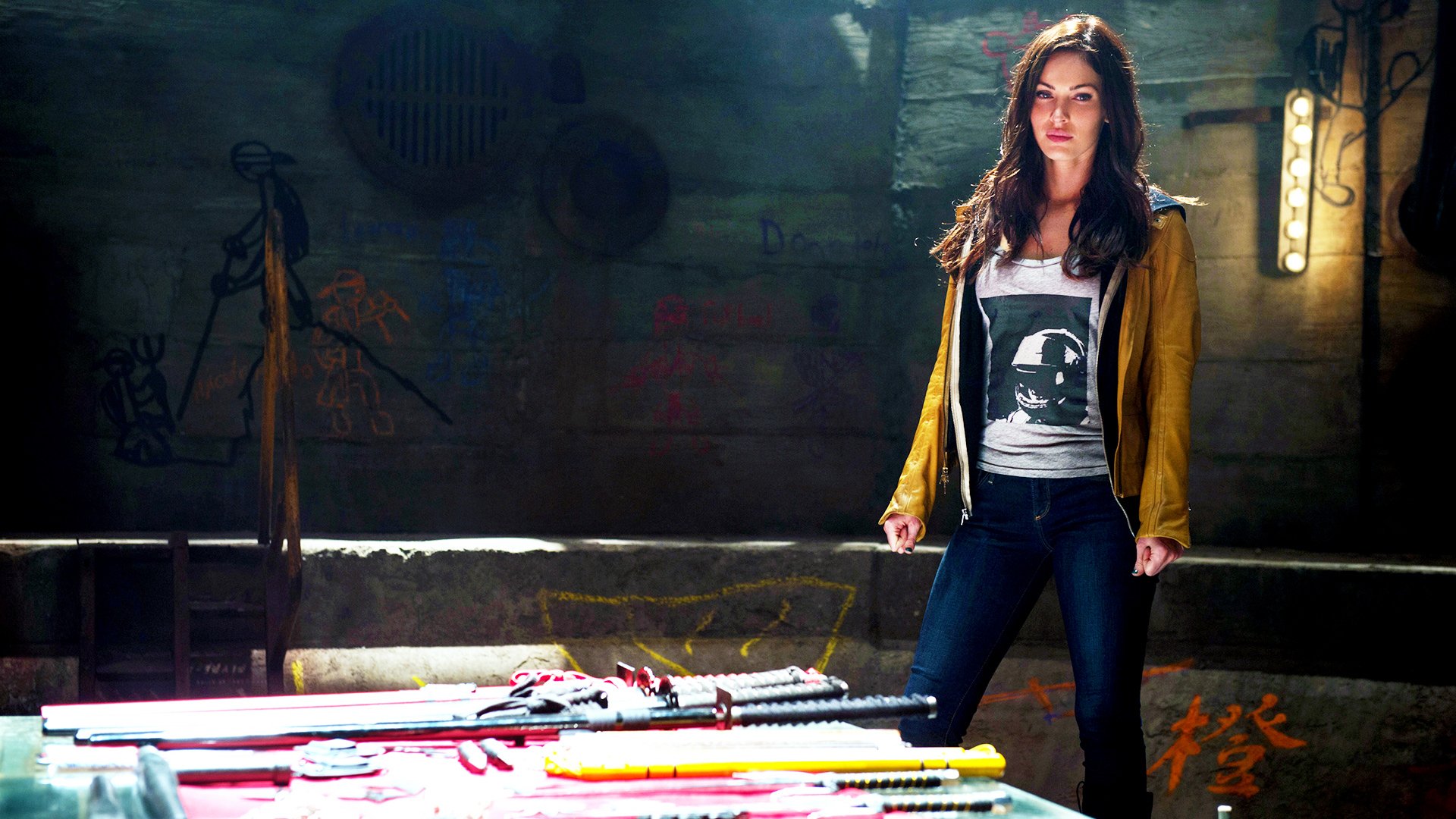HD PC desktop wallpaper featuring a scene from the 2014 movie Teenage Mutant Ninja Turtles with a female character standing confidently in a dimly lit urban setting.