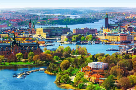 A vibrant view of Stockholm, Sweden showcasing its man-made buildings and scenic waterways in this HD cityscape desktop wallpaper.