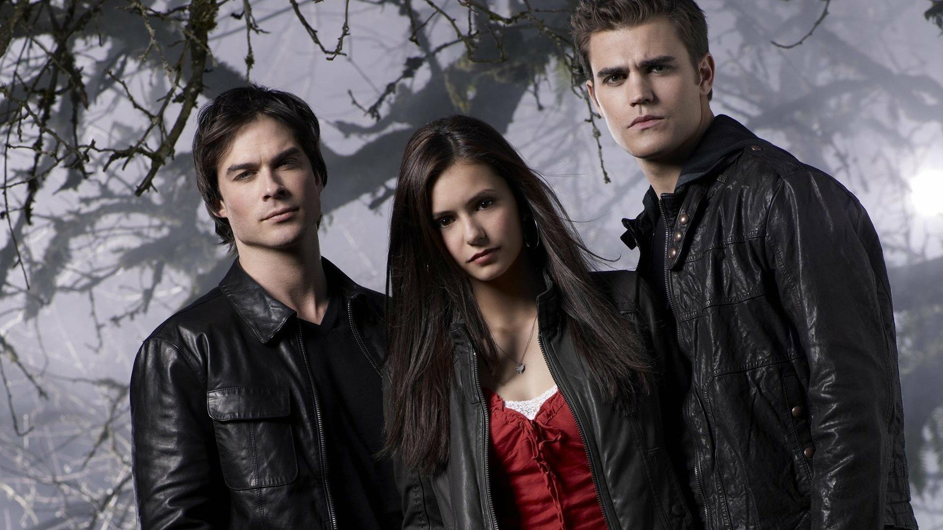 A dramatic HD wallpaper featuring characters from the TV show The Vampire Diaries, set against a haunting backdrop of trees and mist.