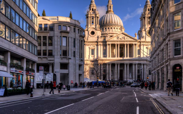 HD image of a bustling London street leading to a grand cathedral. The detailed architecture of the church stands out against the clear sky, framed by buildings on either side.