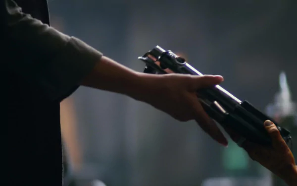 Close-up of two hands exchanging a lightsaber hilt in a cinematic still from the movie Star Wars: Episode VII — 2K Quad HD PC desktop wallpaper.