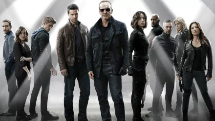 A dynamic HD wallpaper featuring the main characters of Marvel's Agents of S.H.I.E.L.D., standing together in a striking, heroic pose against a dramatic backdrop.