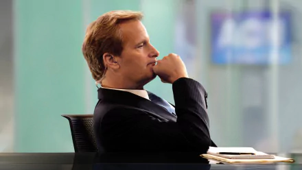 HD wallpaper of a character from The Newsroom (2012), in deep thought at a news desk, for desktop background use.
