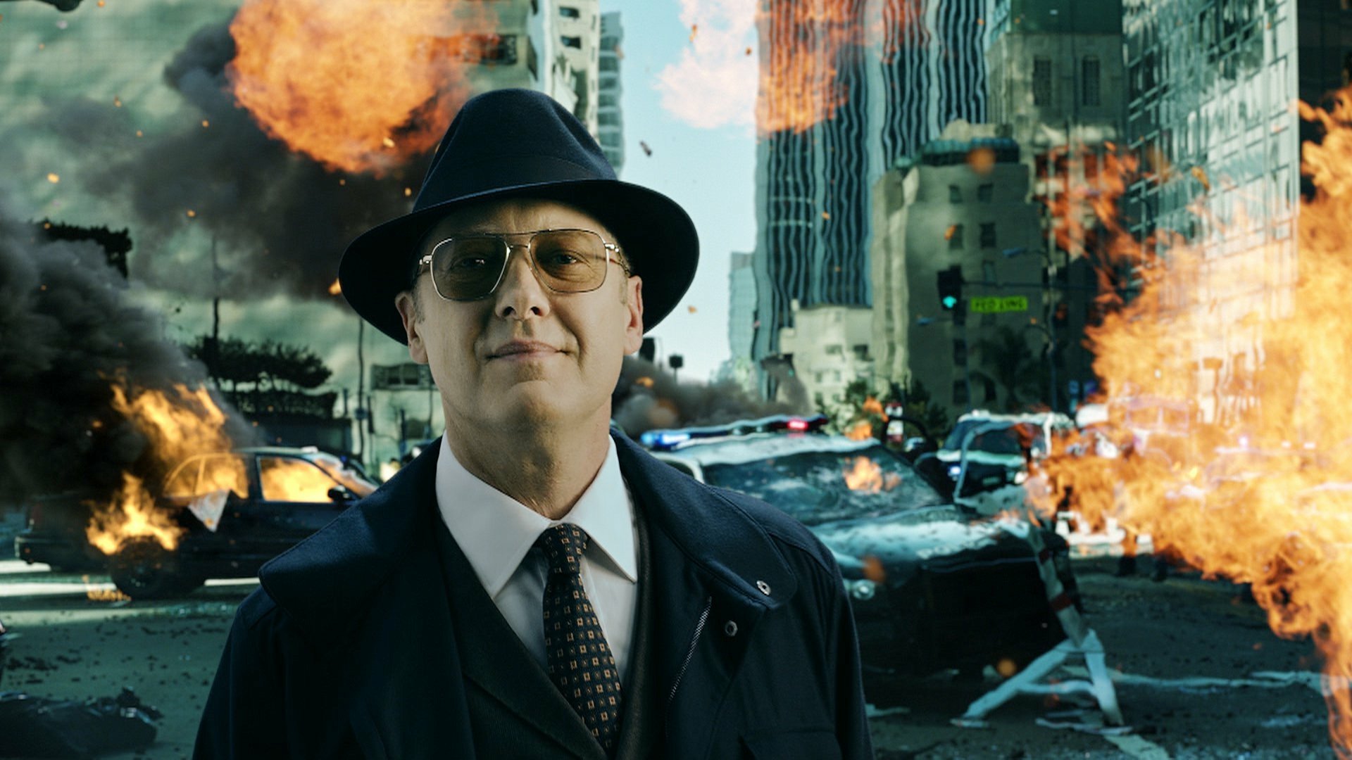 HD PC desktop wallpaper: suited man in fedora amid burning cars and explosions, dramatic TV show scene from The Blacklist.