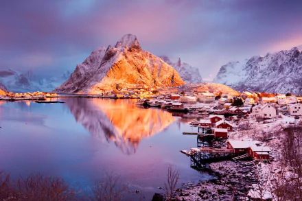 Stunning winter view of Reine, Lofoten, featuring snow-covered mountains reflected in calm waters, creating a serene and captivating HD desktop wallpaper.