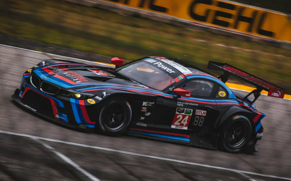 HD desktop wallpaper featuring a sleek BMW Z4 race car speeding on a track, showcasing its dynamic design and vibrant racing livery.