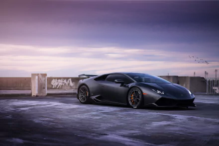 A sleek silver Lamborghini Huracan parked on an urban rooftop, set against a moody sky. This HD wallpaper captures the essence of luxury and performance in supercars.