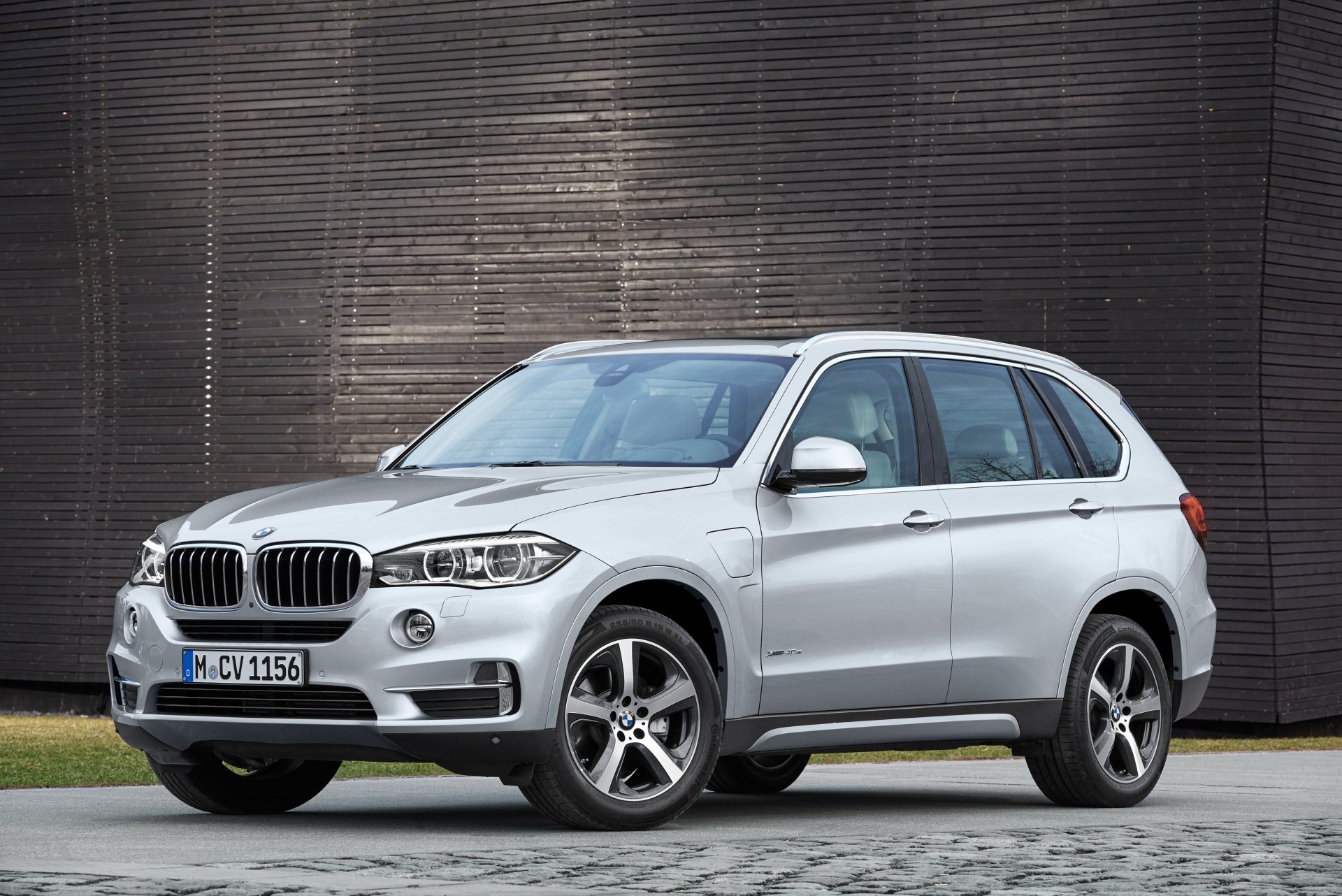 Silver BMW X5 SUV parked before a textured dark wall — 4K Ultra HD PC desktop wallpaper and background.