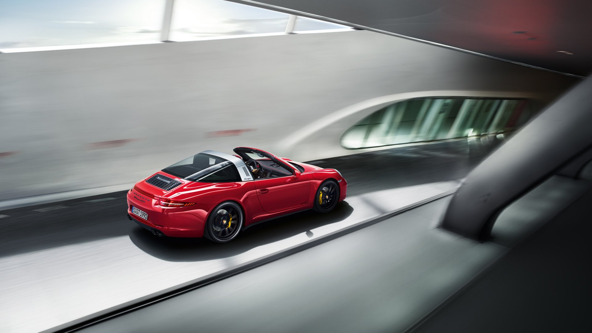 Red Porsche 911 Targa GTS driving through a modern tunnel, rear three-quarter view — 2K Quad HD PC desktop wallpaper of the Porsche 911 vehicle.