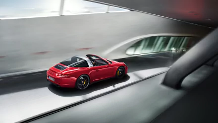 Red Porsche 911 Targa GTS driving through a modern tunnel, rear three-quarter view — 2K Quad HD PC desktop wallpaper of the Porsche 911 vehicle.