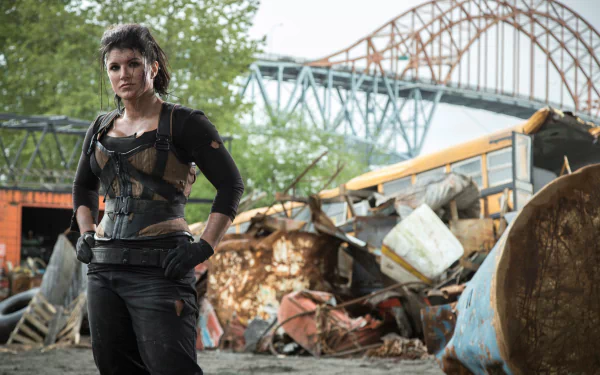 A striking HD wallpaper featuring Gina Carano as a tough character in a gritty setting, reminiscent of the action-packed movie Deadpool, with an industrial backdrop and bold stance.